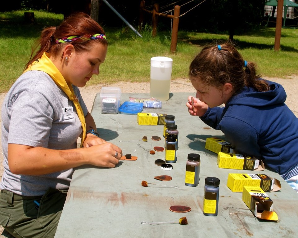 Family Camp participant working on a leather craft