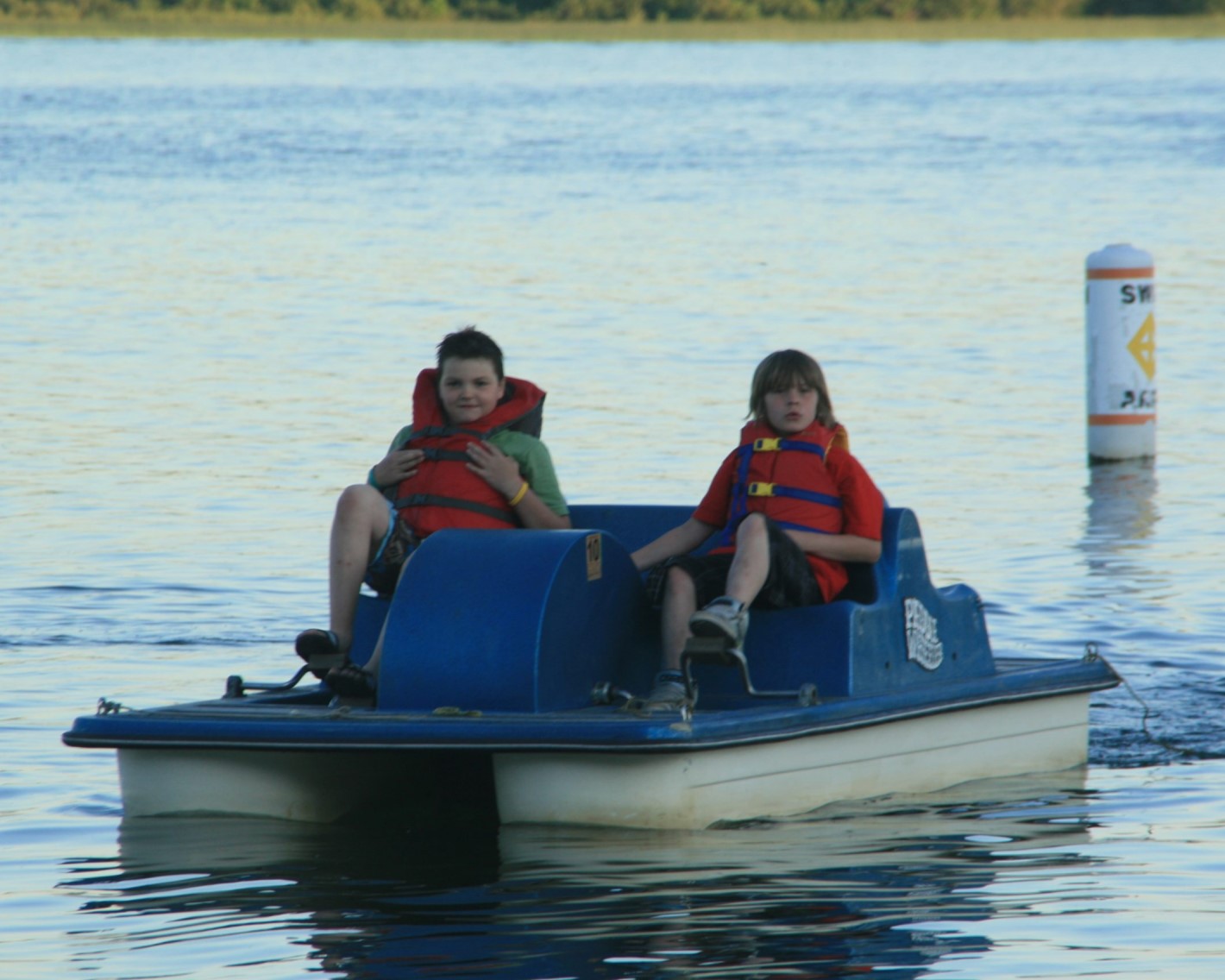 Picture of two kids using a paddleboat on the lake