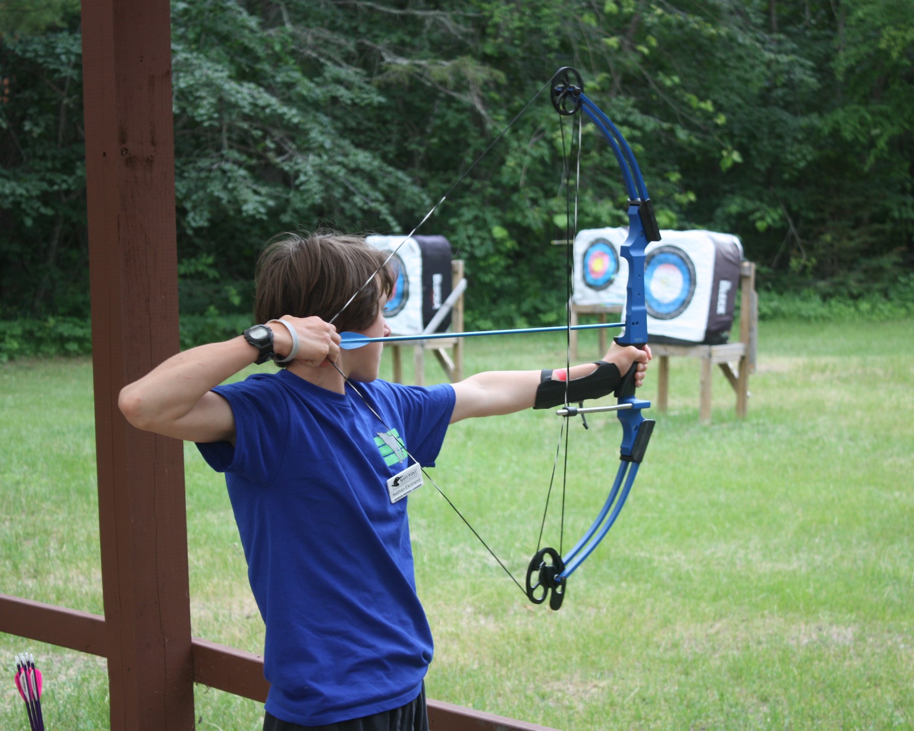 A Scout shooting a compound bow at the archery range