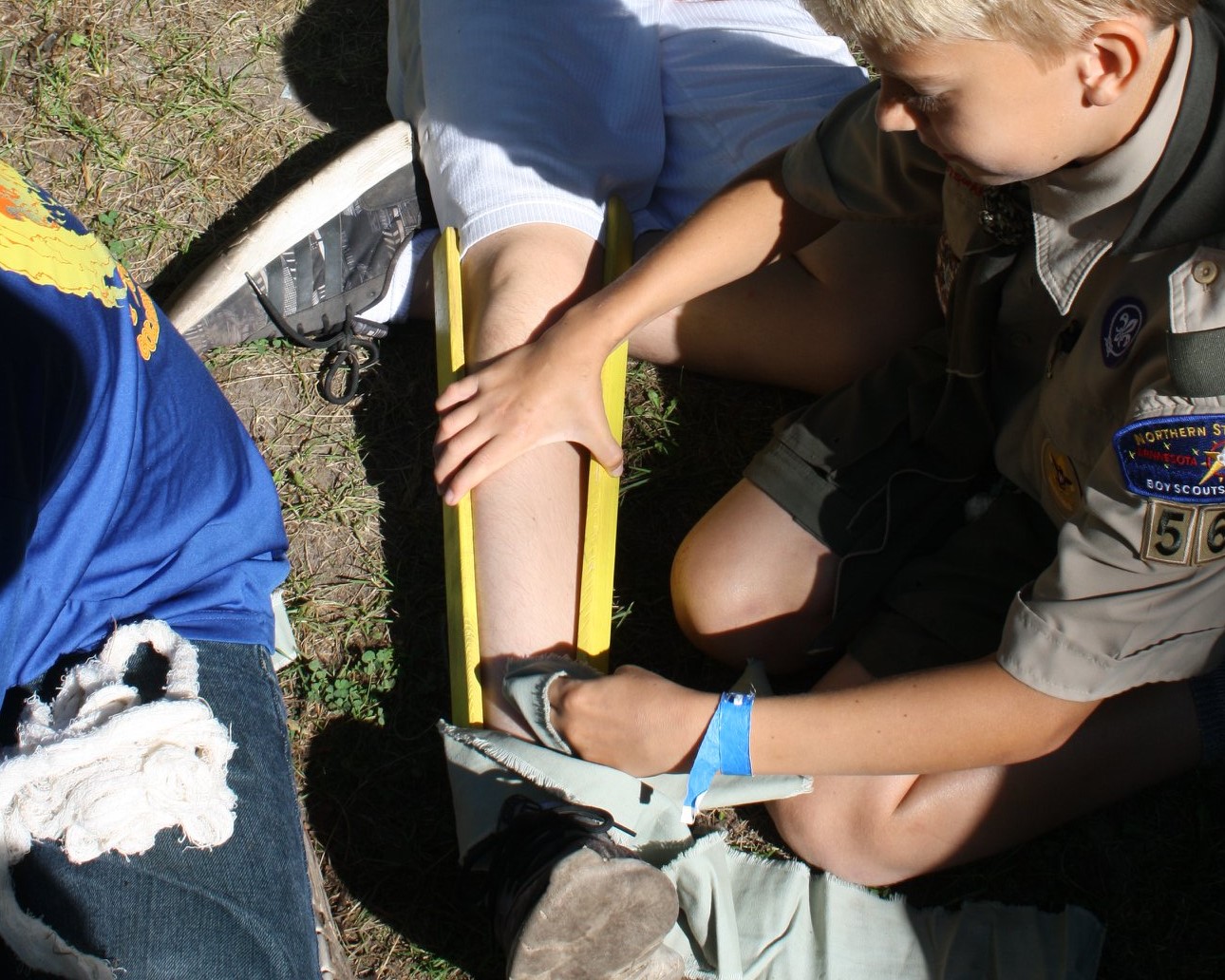 A young Scout practicing making a splint 